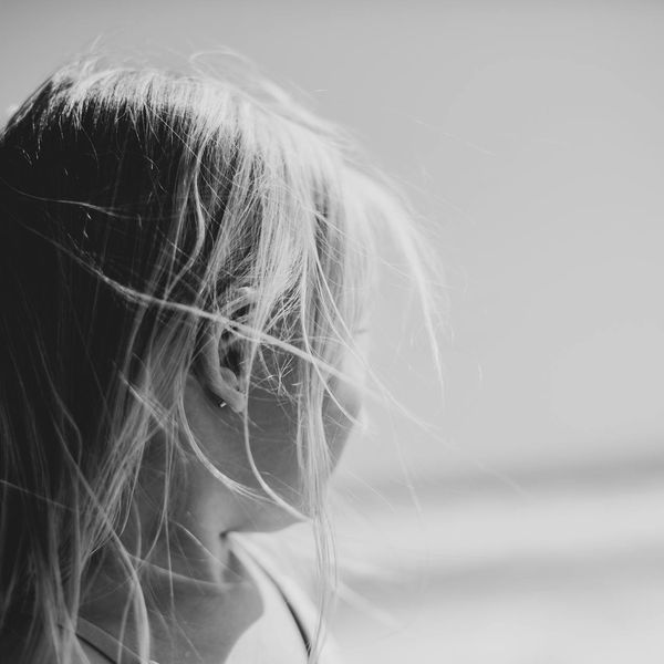Person feeling energized and stretching outdoors with a serene background.